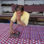 Man stamping fabric with blue paint overlay